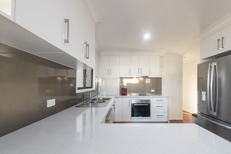 A Kitchen With White Cabinets and Stainless Steel Appliances — Mackay Cabinetmaking Service In Rural View, QLD