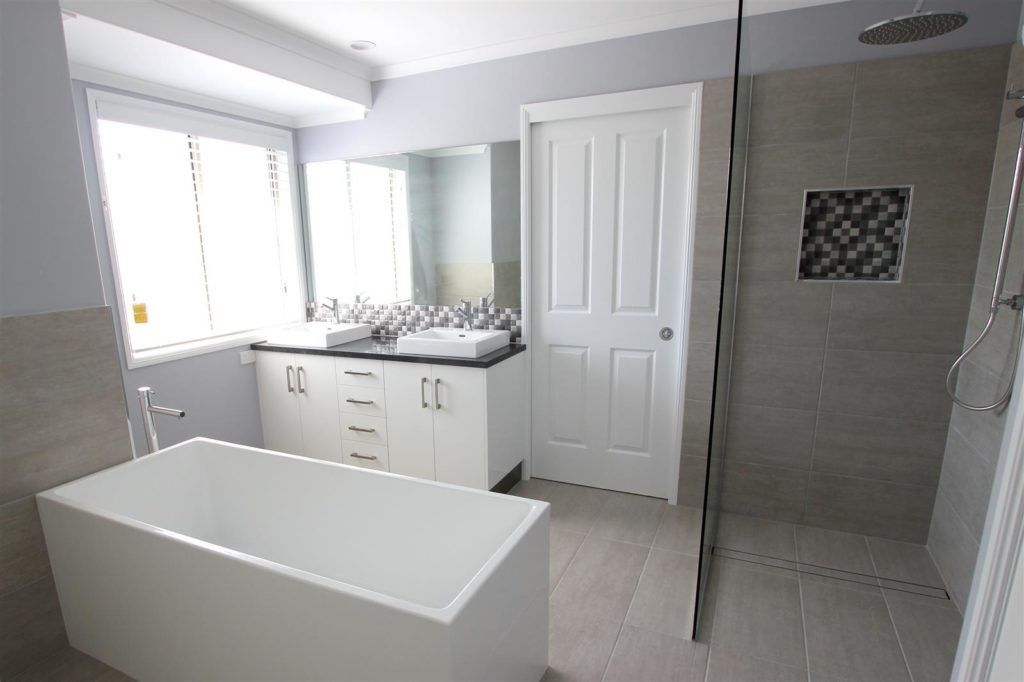 A Bathroom With a Bathtub, Sink, and Walk in Shower — Mackay Cabinetmaking Service In Rural View, QLD