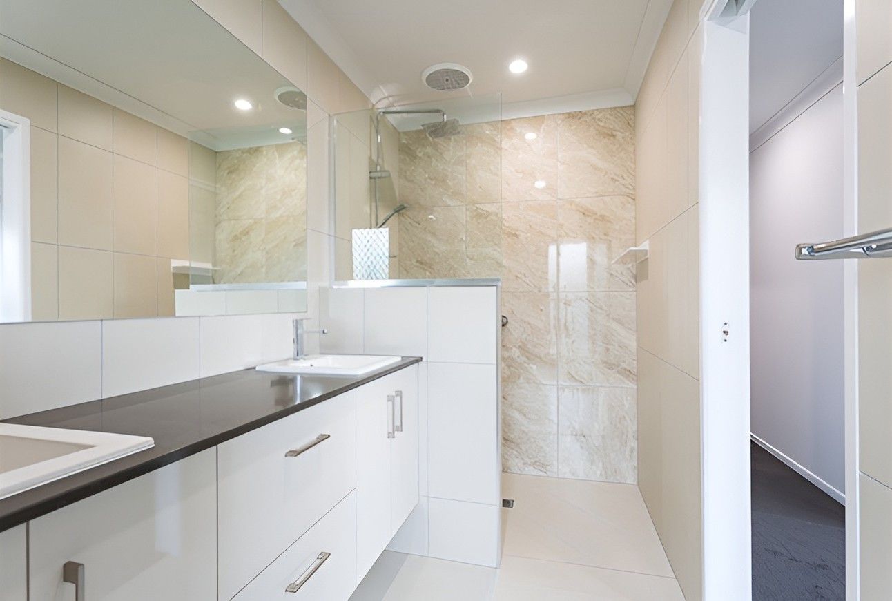 A Bathroom With a Sink , Mirror and Walk in Shower — Mackay Cabinetmaking Service In Glenella, QLD