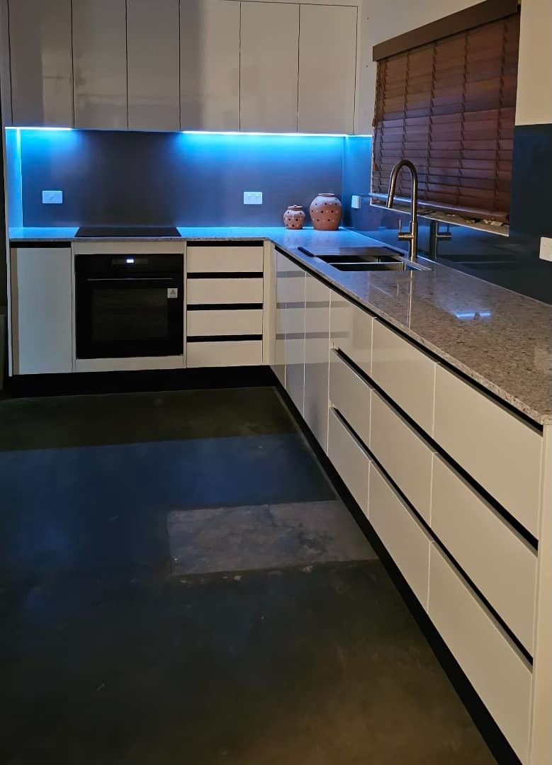 A Kitchen With White Cabinets and Granite Counter Tops — Mackay Cabinetmaking Service In Glenella, QLD