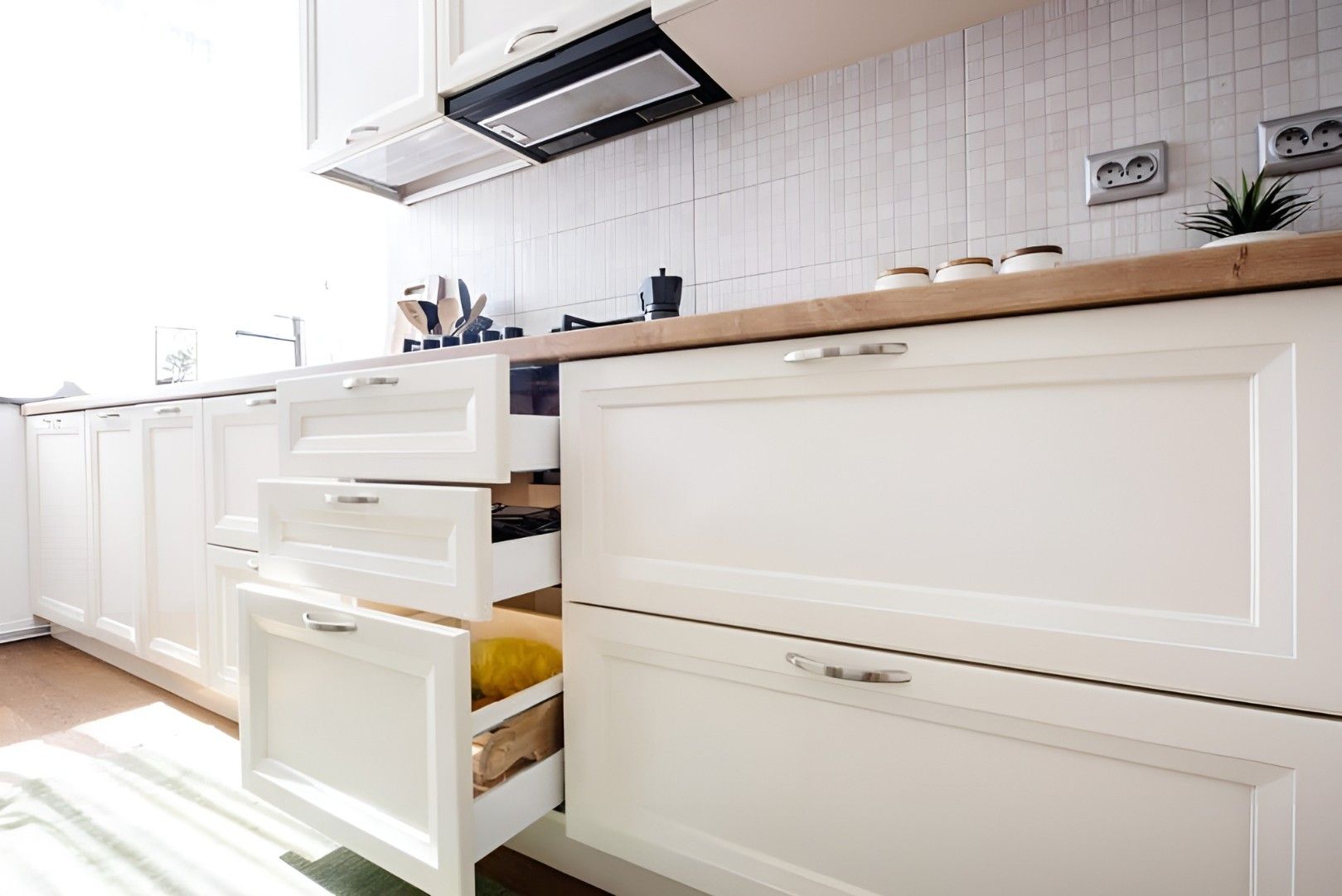 A Kitchen With White Cabinets and Drawers Open — Mackay Cabinetmaking Service In Glenella, QLD