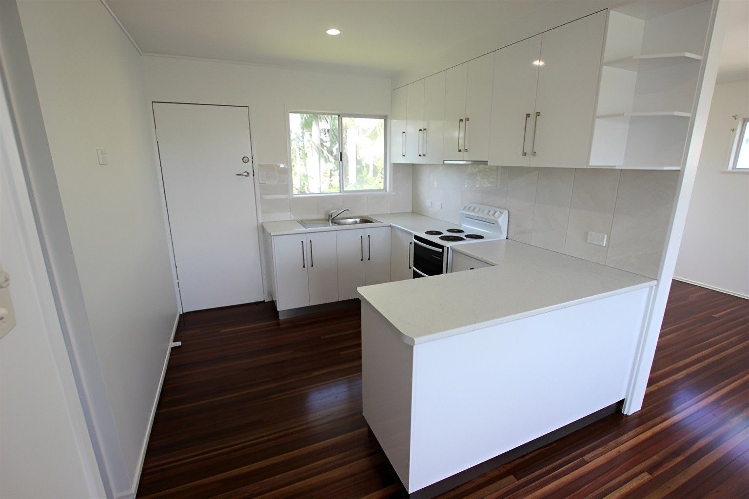 A Kitchen With White Cabinets and a Wooden Floor — Mackay Cabinetmaking Service In Moranbah, QLD