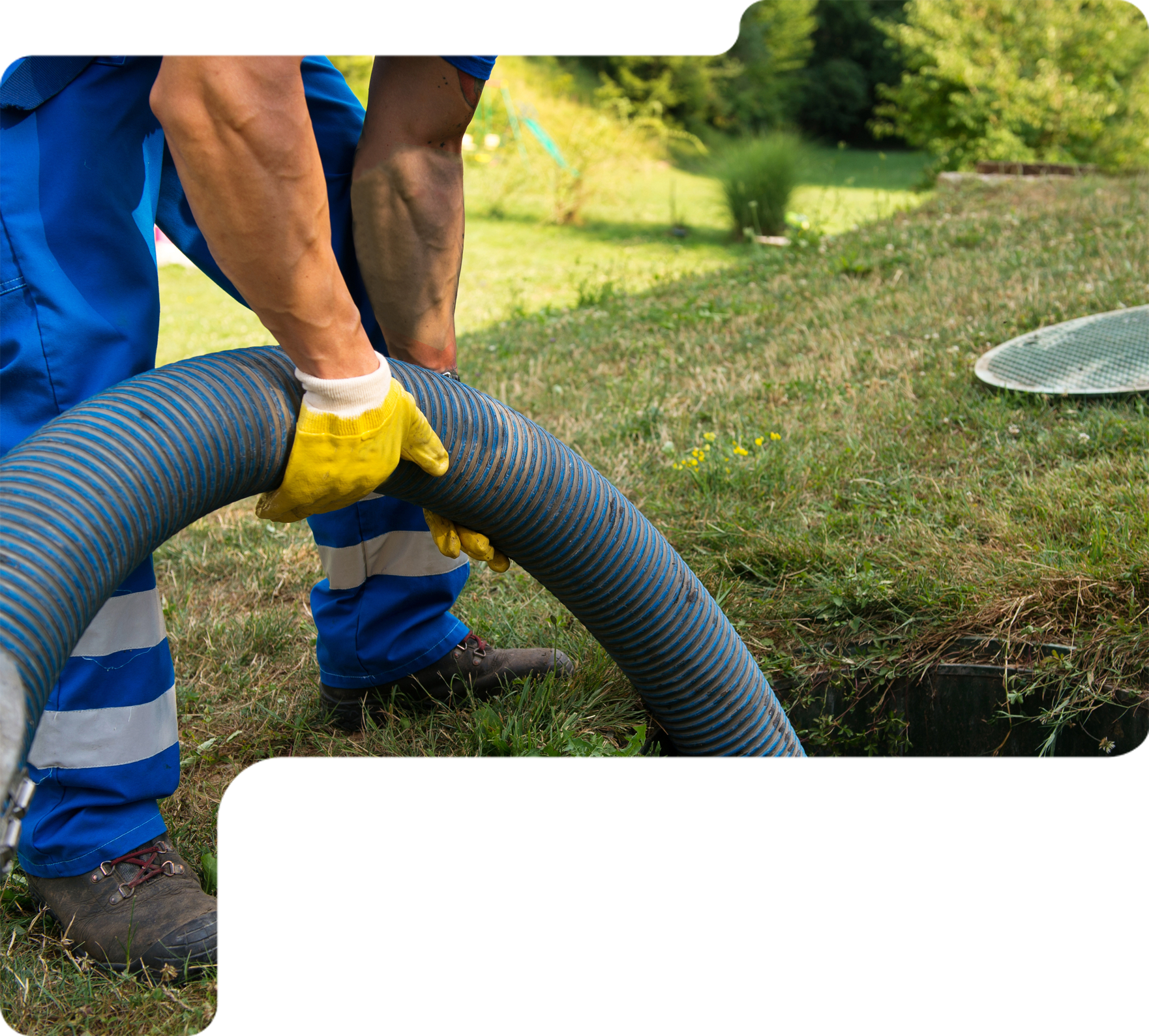 Worker in blue uniform and yellow gloves handling a large hose on a grassy lawn