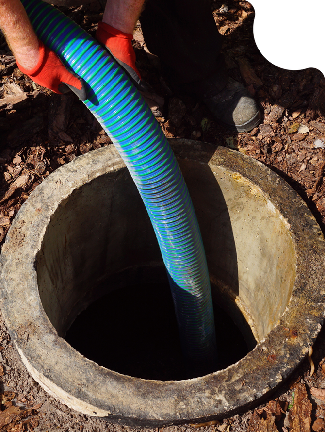 Blue hose being lowered into an open concrete manhole outdoors