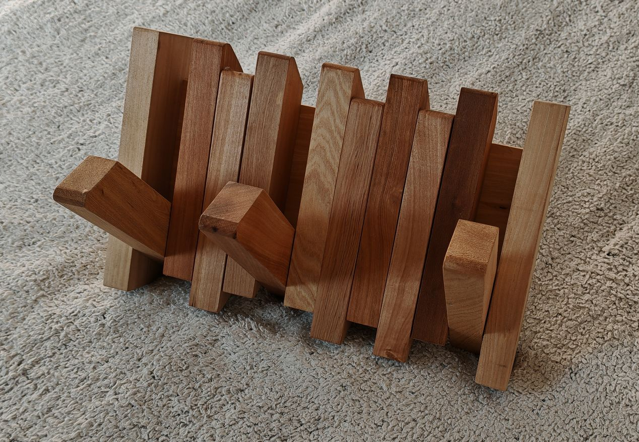 Bloques de madera apilados en una fila inclinada sobre una superficie alfombrada.