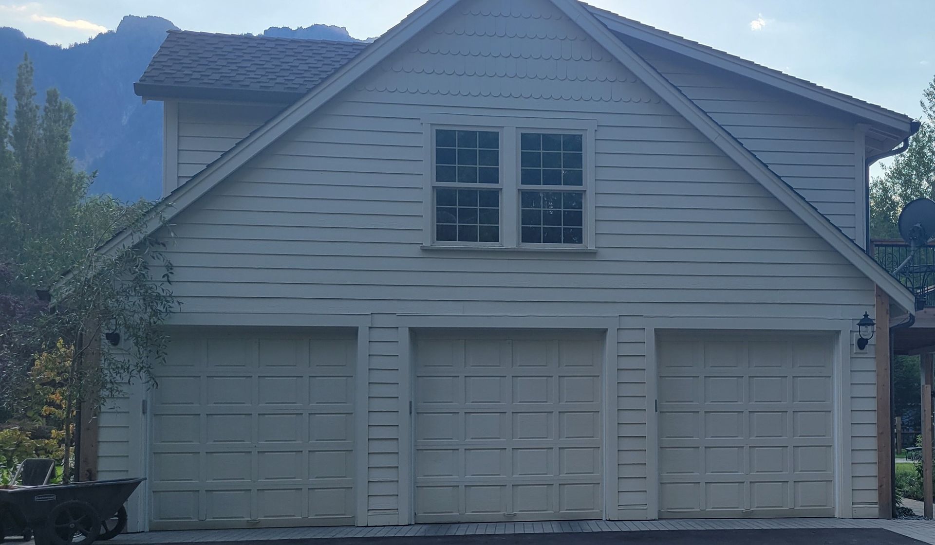 Home with an old white panel garage doors before replacement
