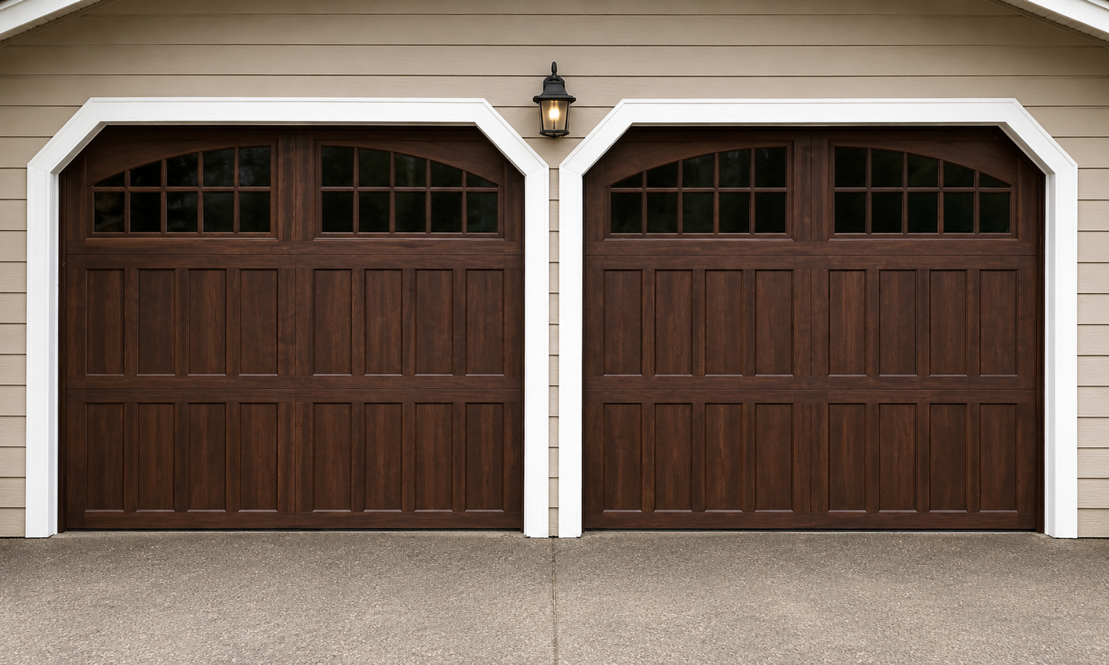 Close-up of wood-tone steel carriage house garage doors with arched windows