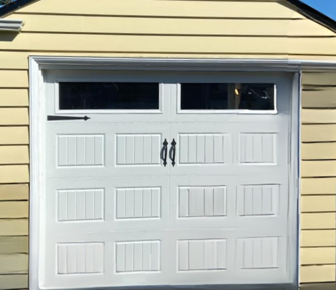 White steel carriage house garage door with vertical panels, small windows, and black handles