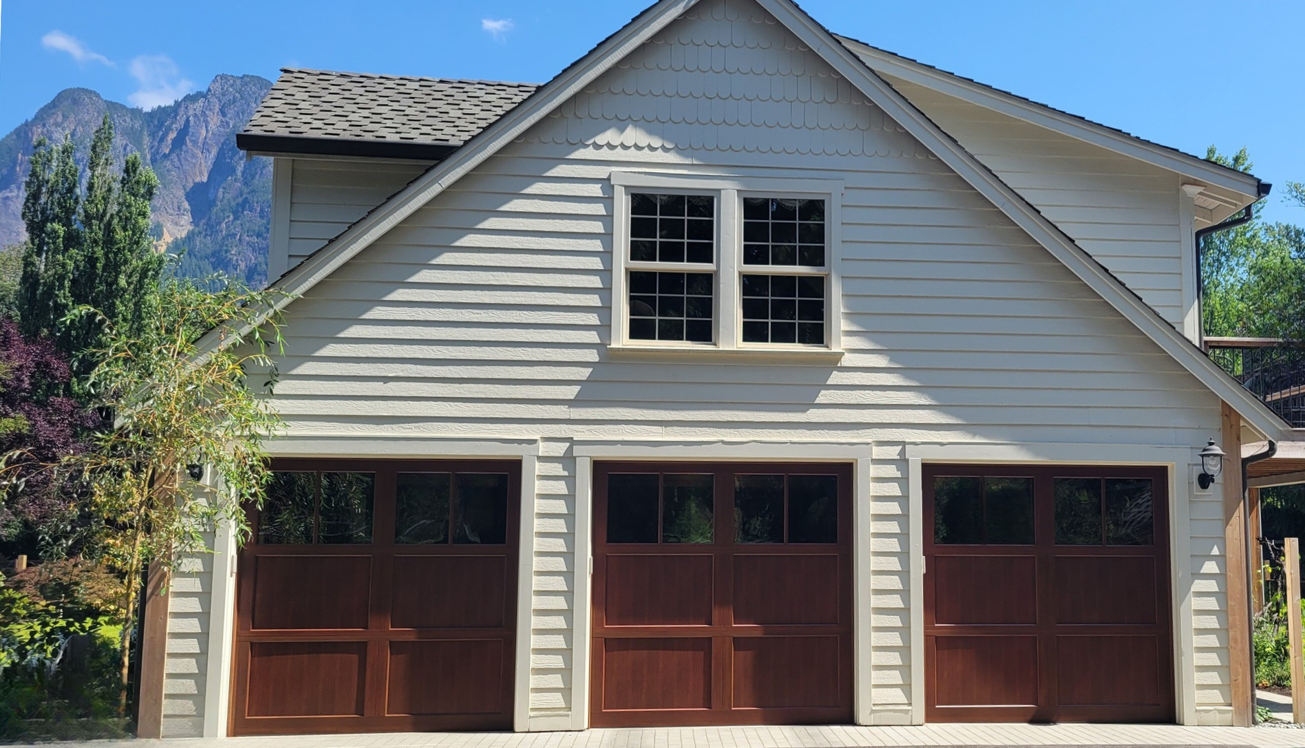 Home with new dark wood carriage house garage doors