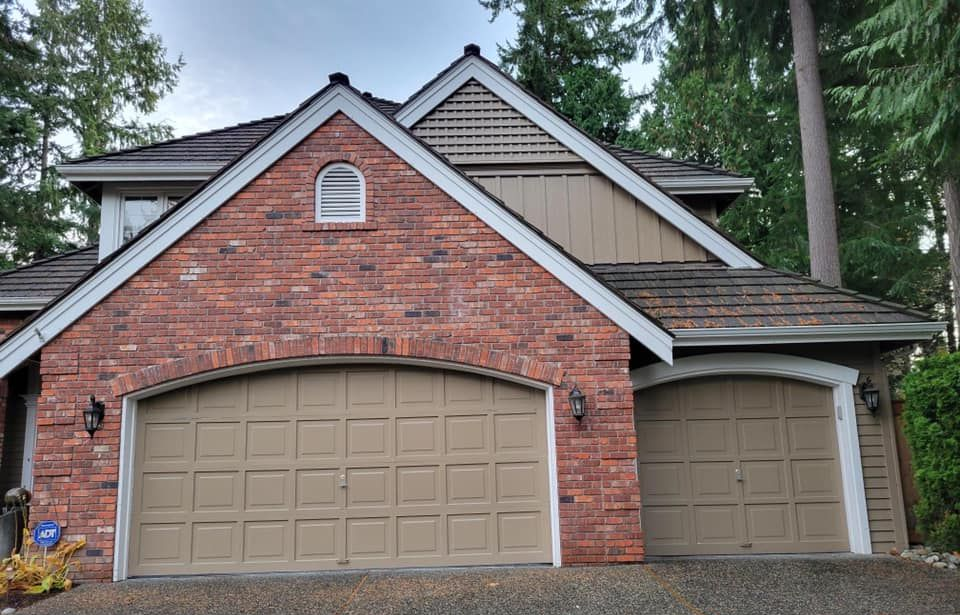 Brick home with an old plain panel garage door before replacement