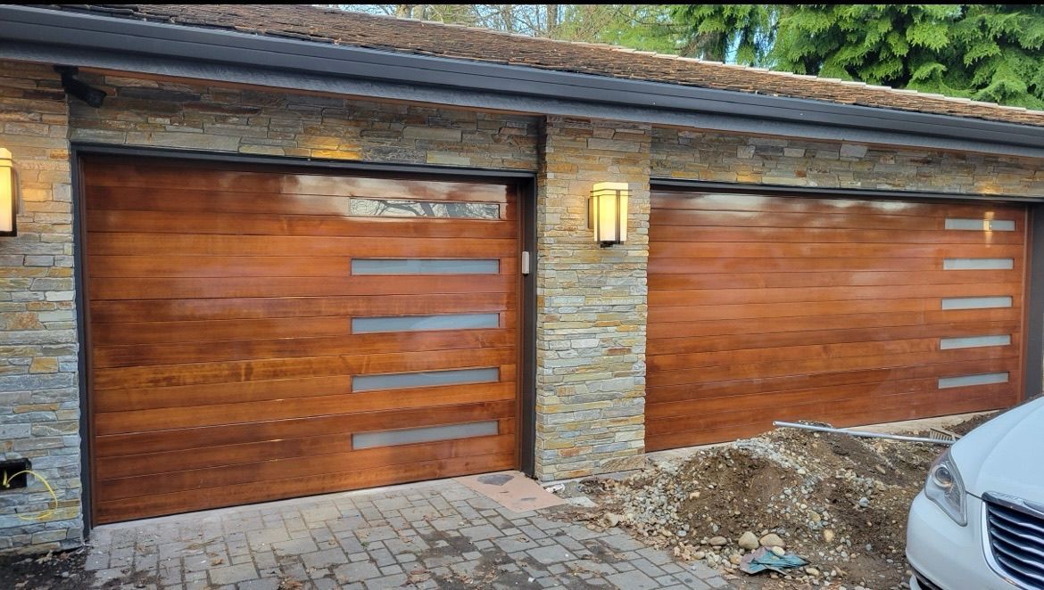 Wood-tone contemporary garage door with window accents on a modern home