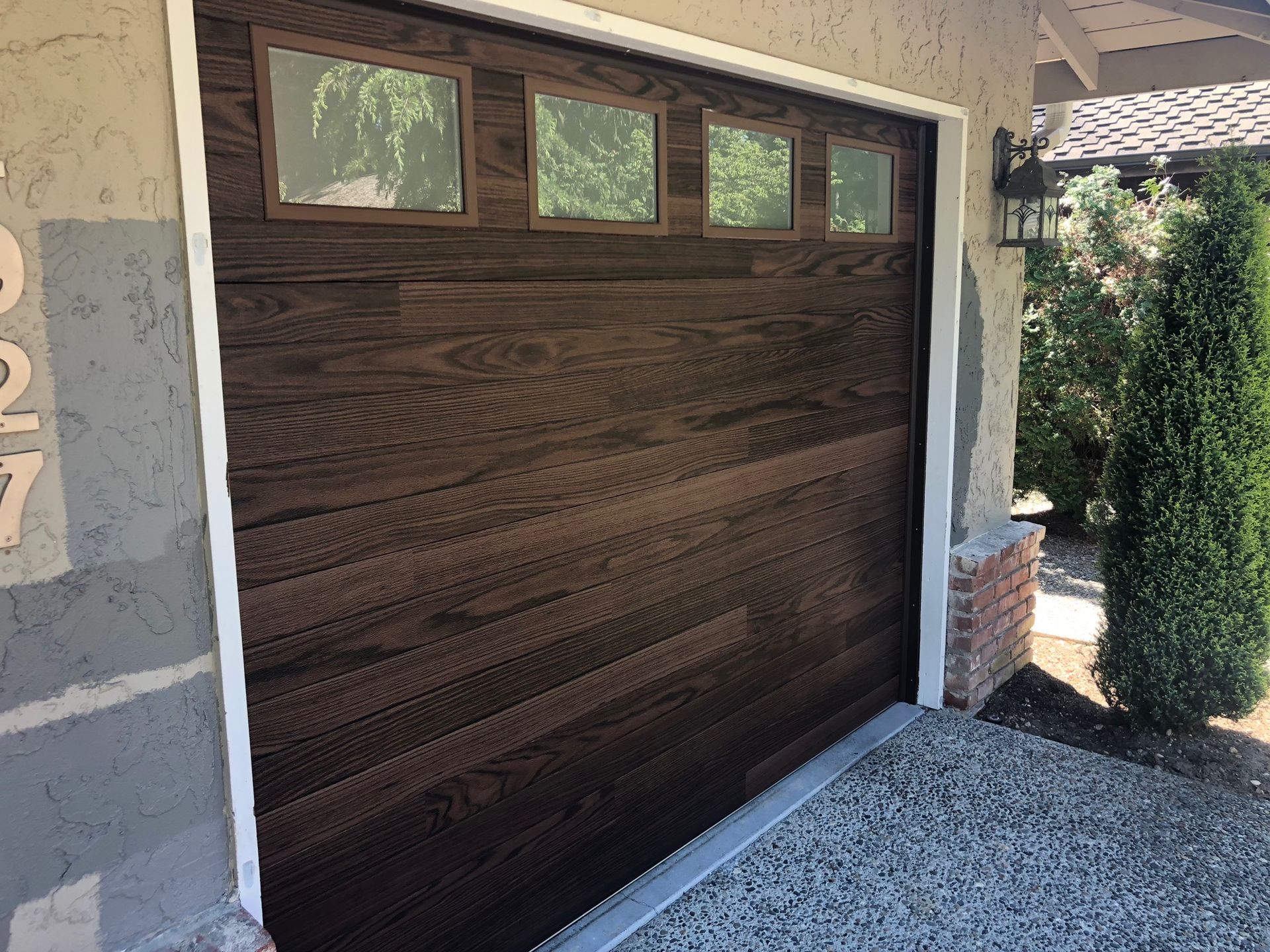 Close-up of a wood-tone garage door with window accents
