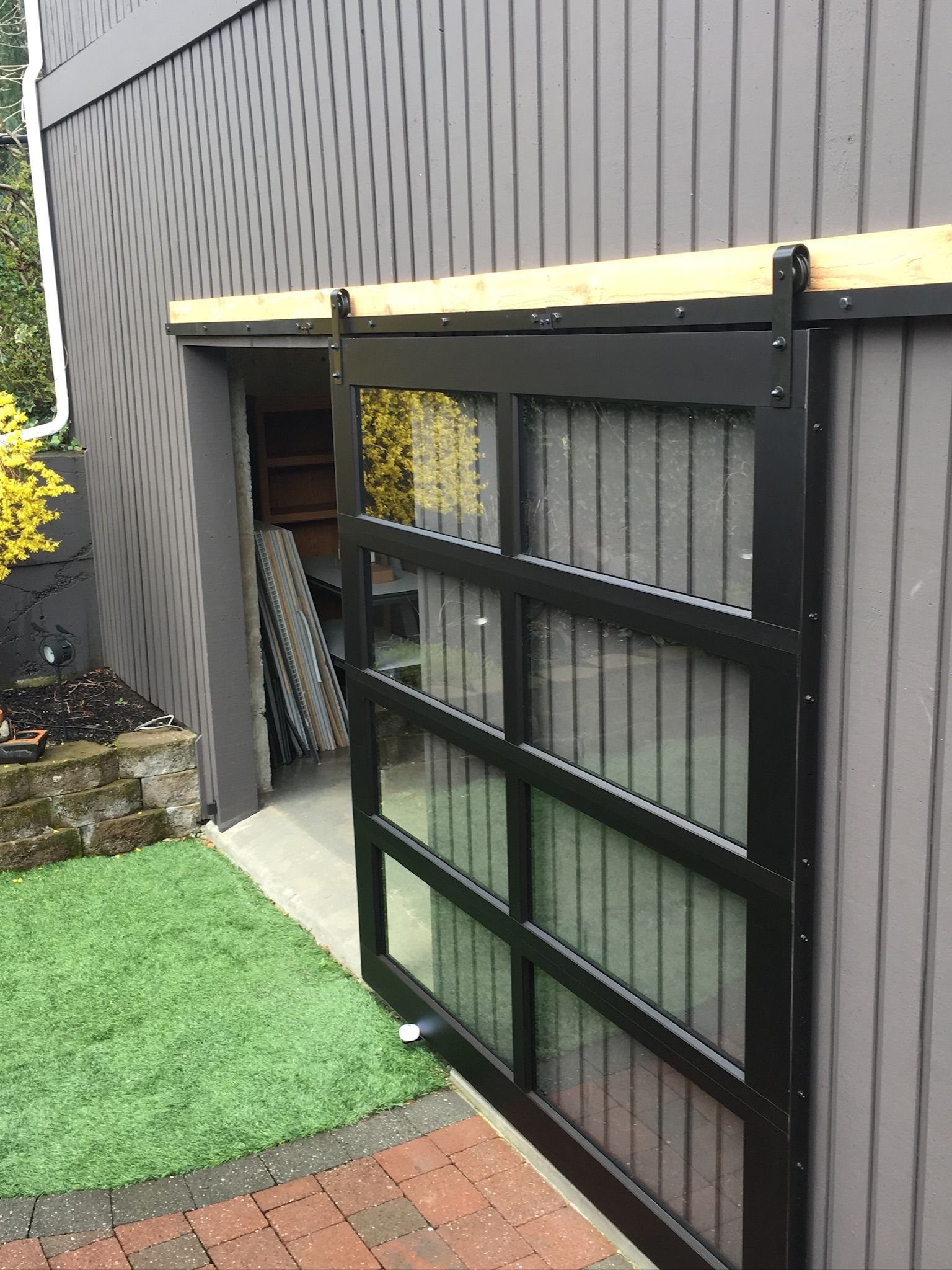 Close-up of a black-frame glass barn-style garage door