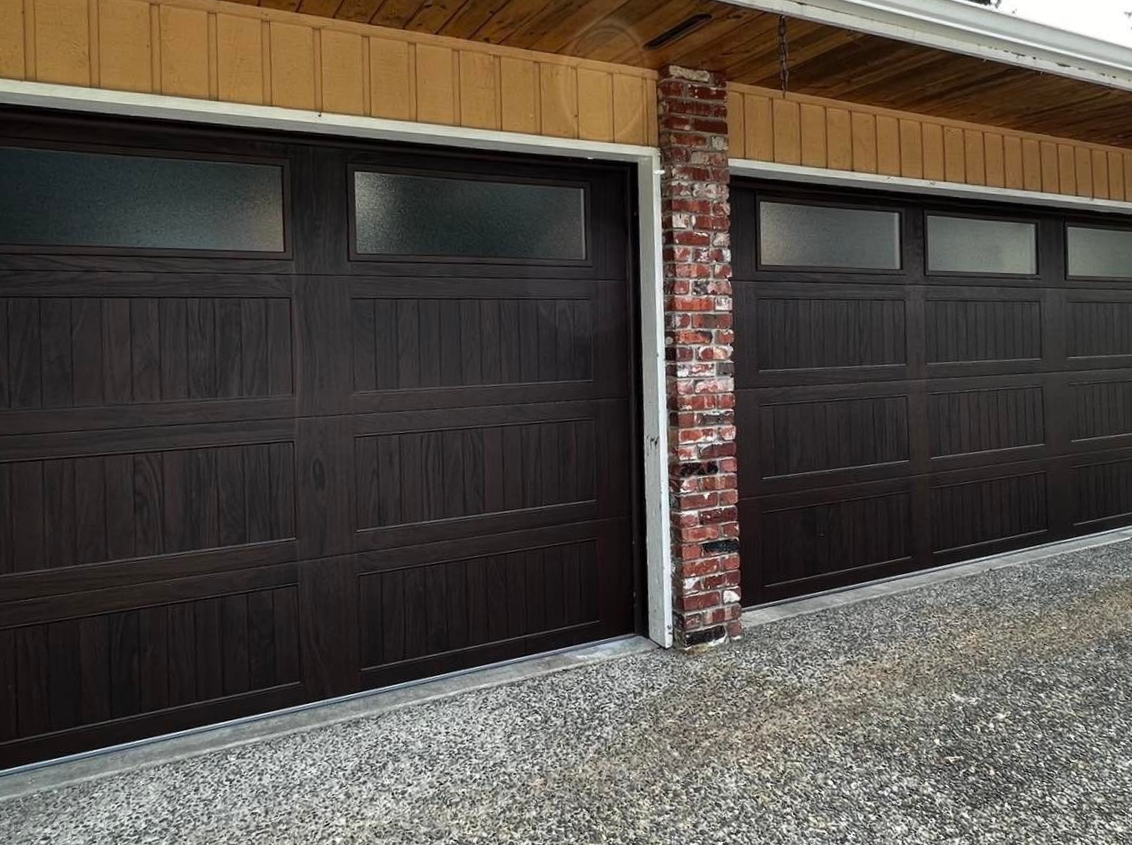 Close-up of a dark wood-tone garage door on a brick home
