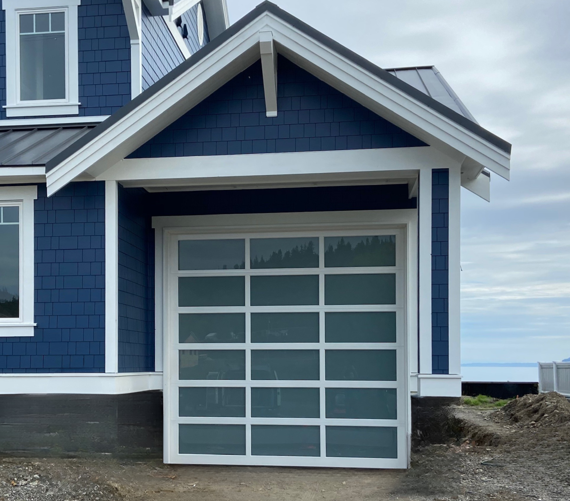 White-frame frosted glass garage door on a blue coastal home