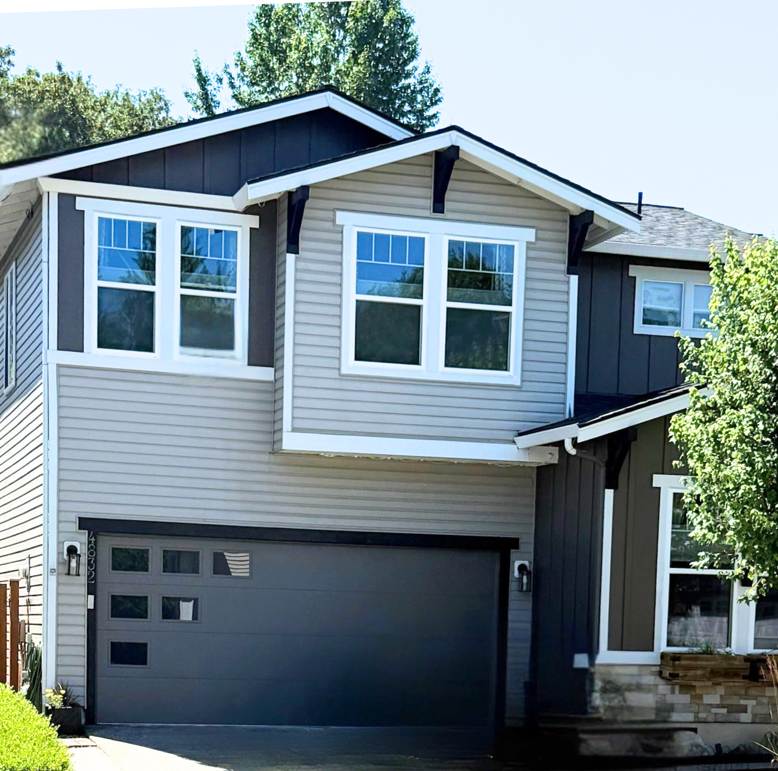 Dark charcoal contemporary garage door on a two-story home