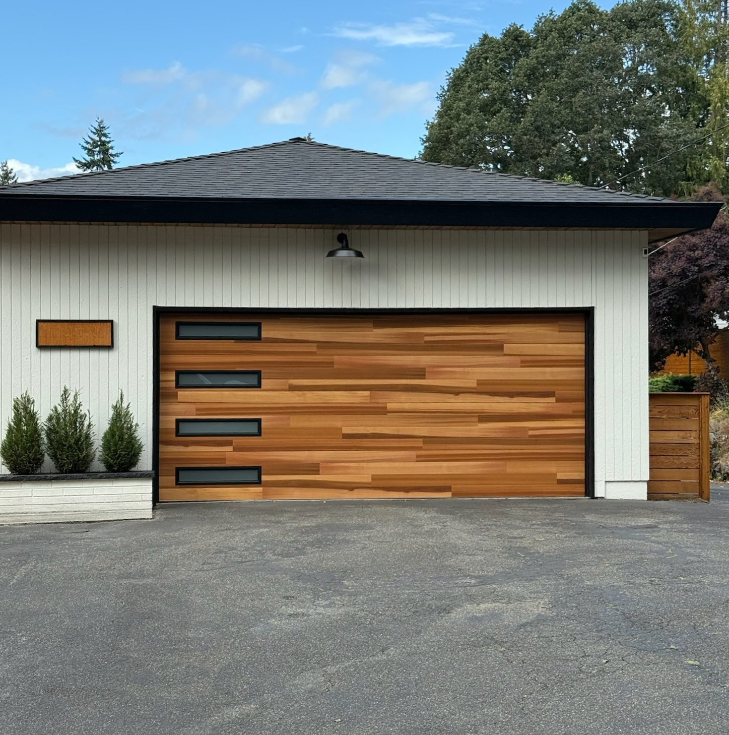 Wood-tone contemporary garage door on a white home