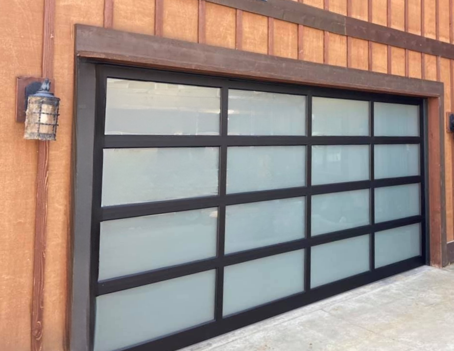 Home with a new black-frame glass contemporary garage door
