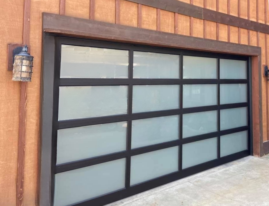 Close-up of a black-frame frosted glass garage door with wood accent