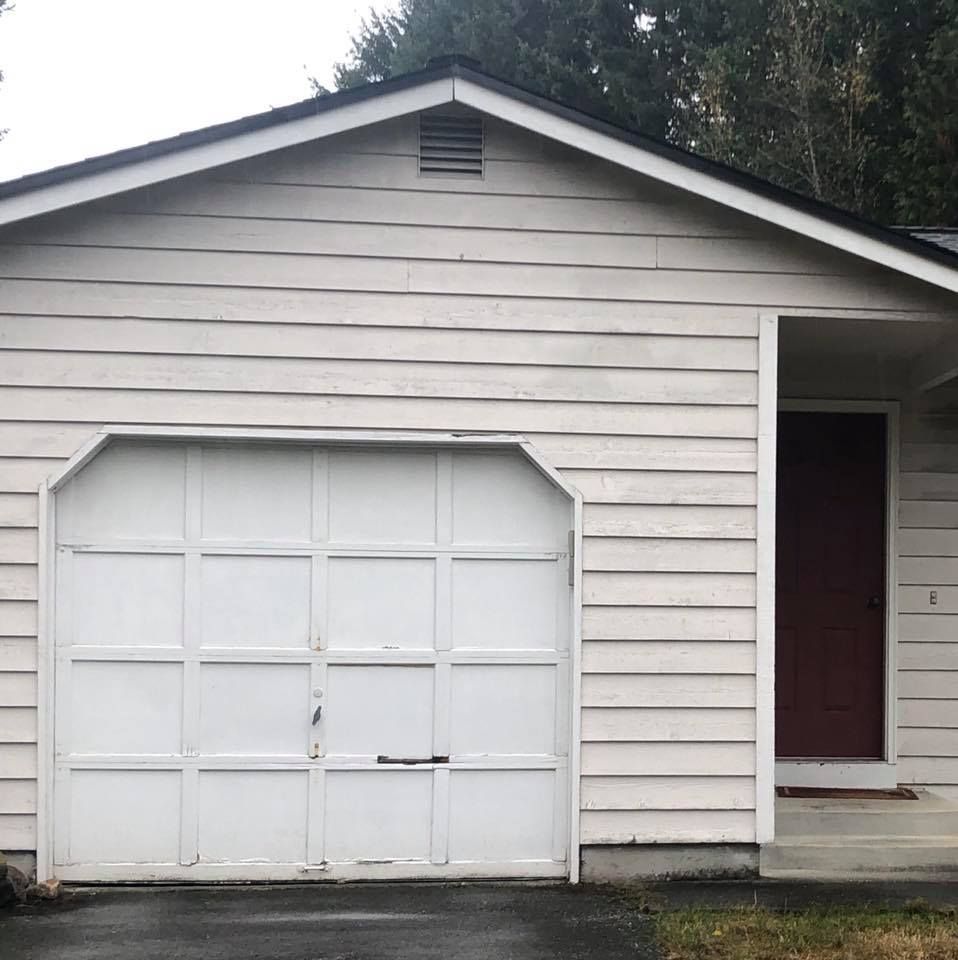 Home with an old worn garage door before replacement