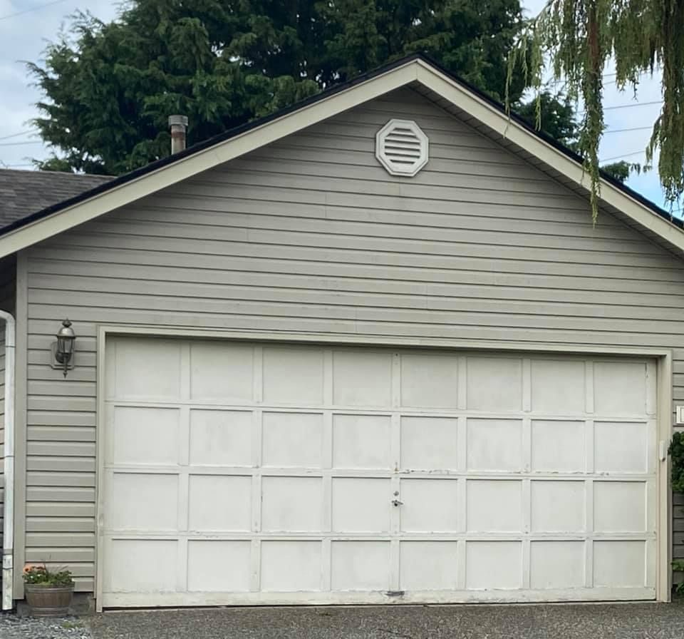 Home with an old cream panel garage door before replacement