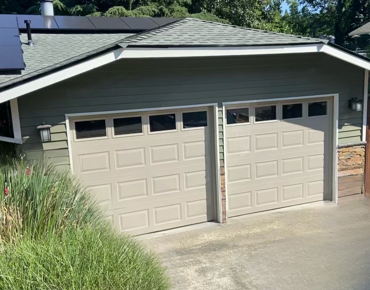 Tan traditional steel garage doors on a stucco home
