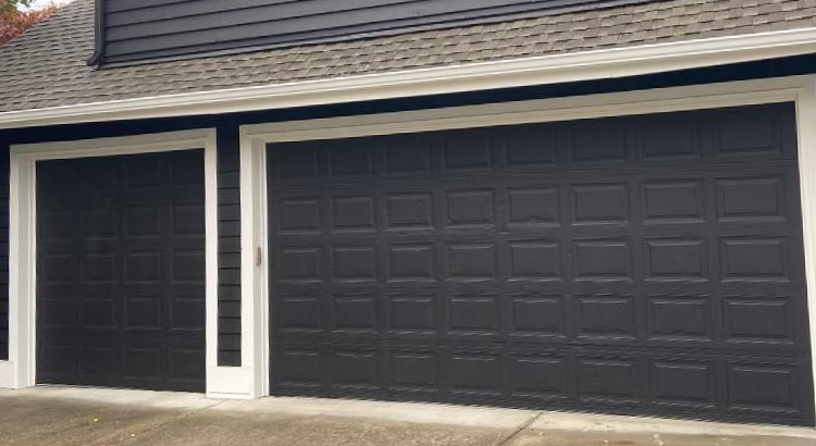 Black traditional steel garage door with white trim casing