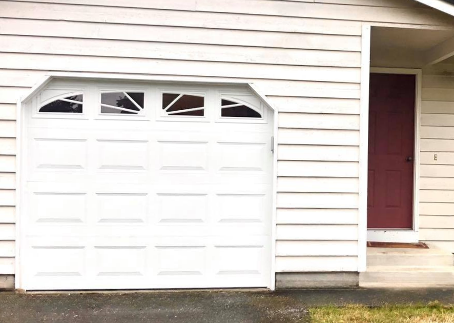 White traditional steel garage door with a sunburst window pane