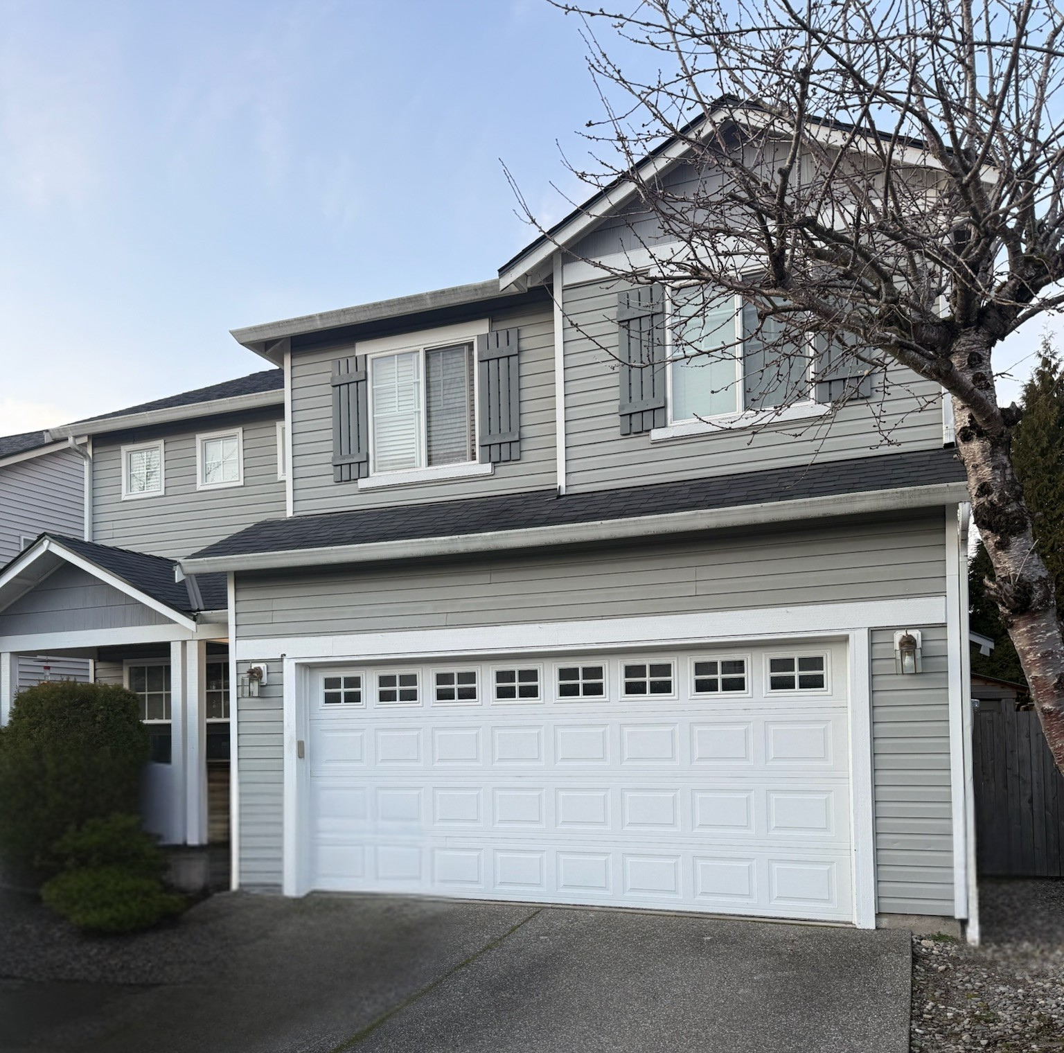 White traditional steel garage door with windows on a residential home