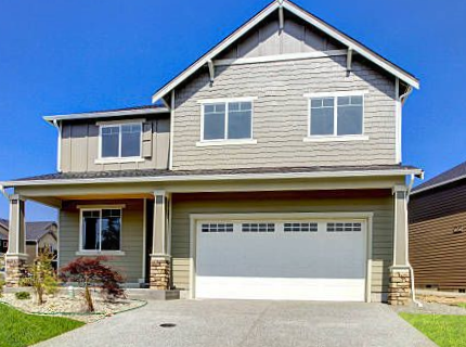 White traditional steel garage door with square windows on a two-story home