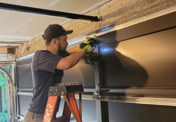 Technician using a drill to repair a garage door