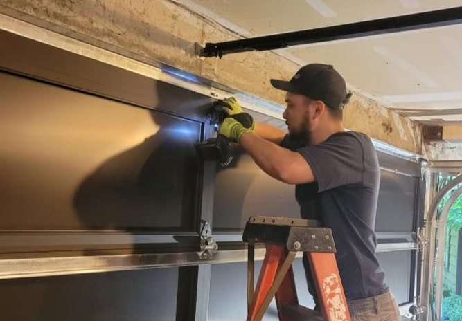 Technician adjusting a garage door opener during installation