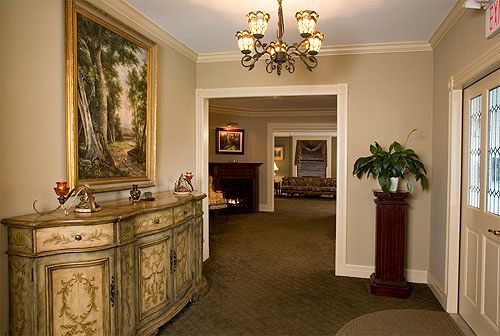 A hallway with a dresser and a picture on the wall