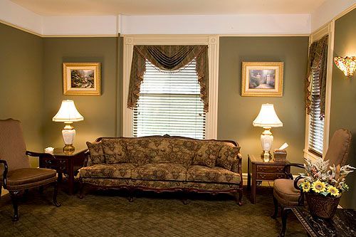 A living room with a couch , chairs and lamps
