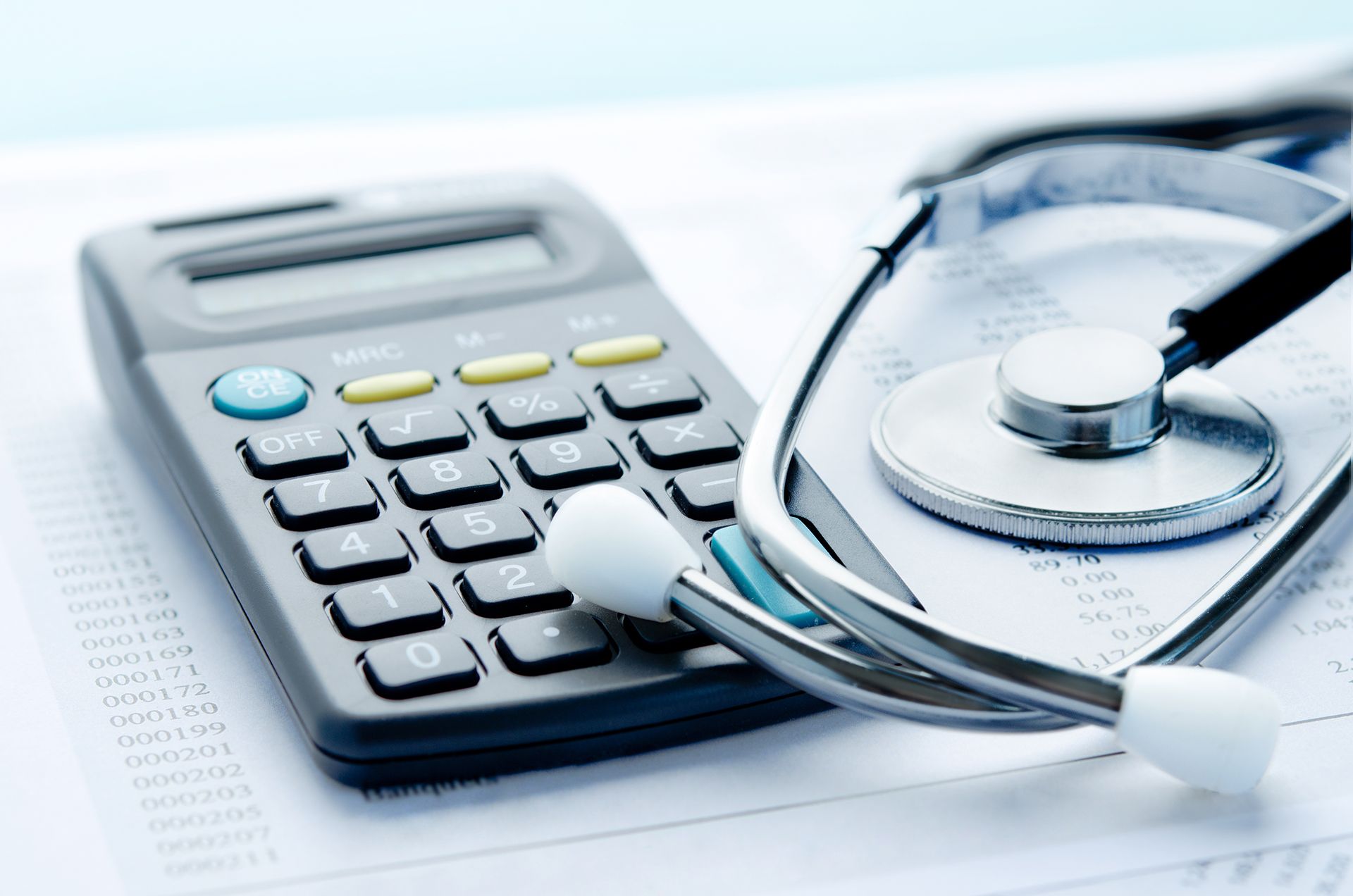 A stethoscope is laying on top of a calculator