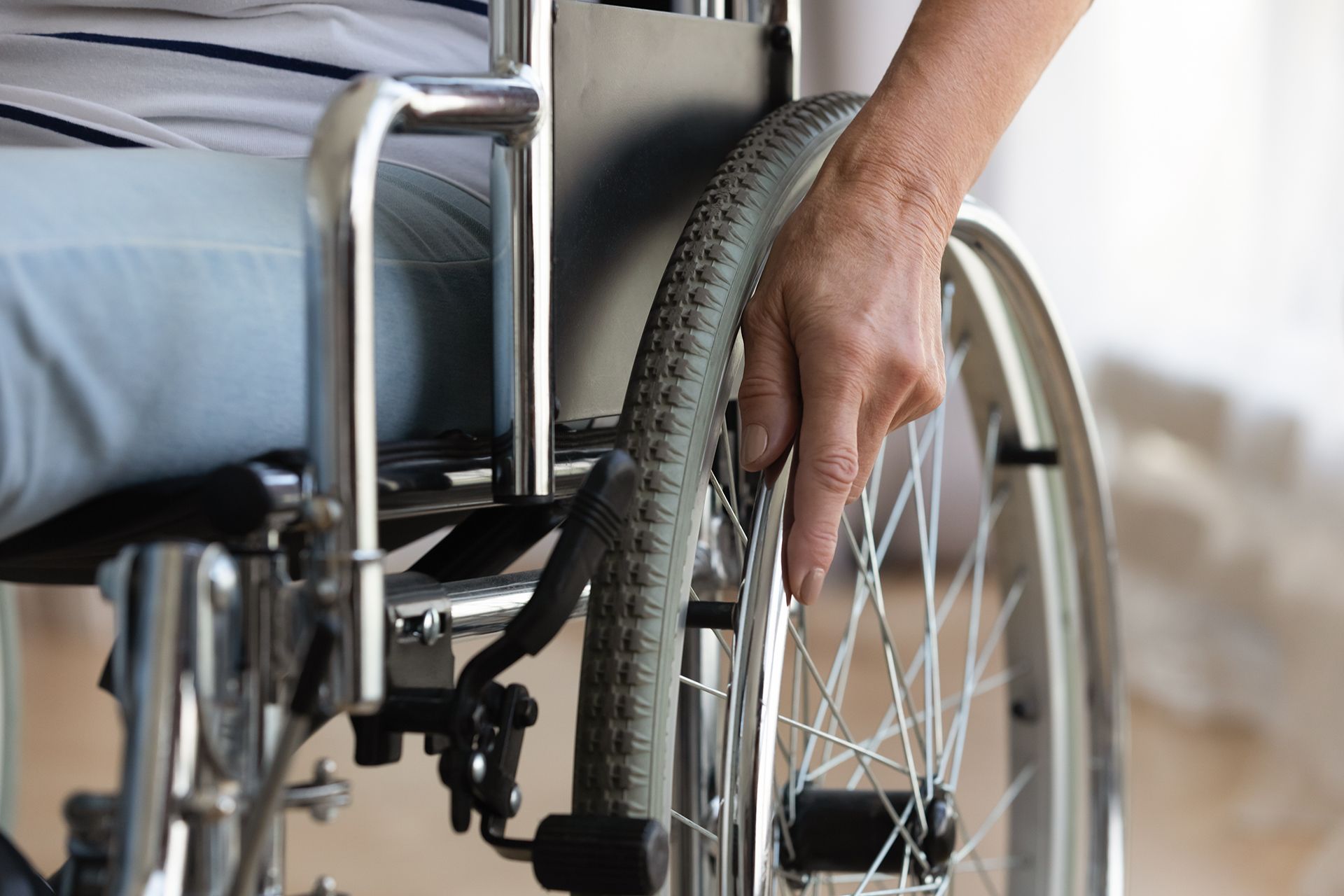 A person in a wheelchair is adjusting the wheel.