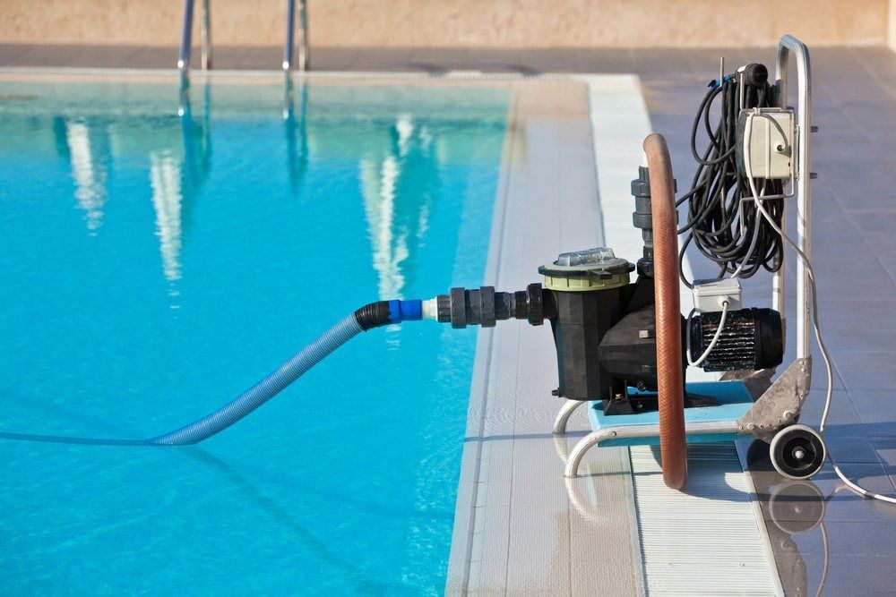 Pool Pump System Next to a Turquoise Pool — Port Douglas Pool Shop in Craiglie, QLD