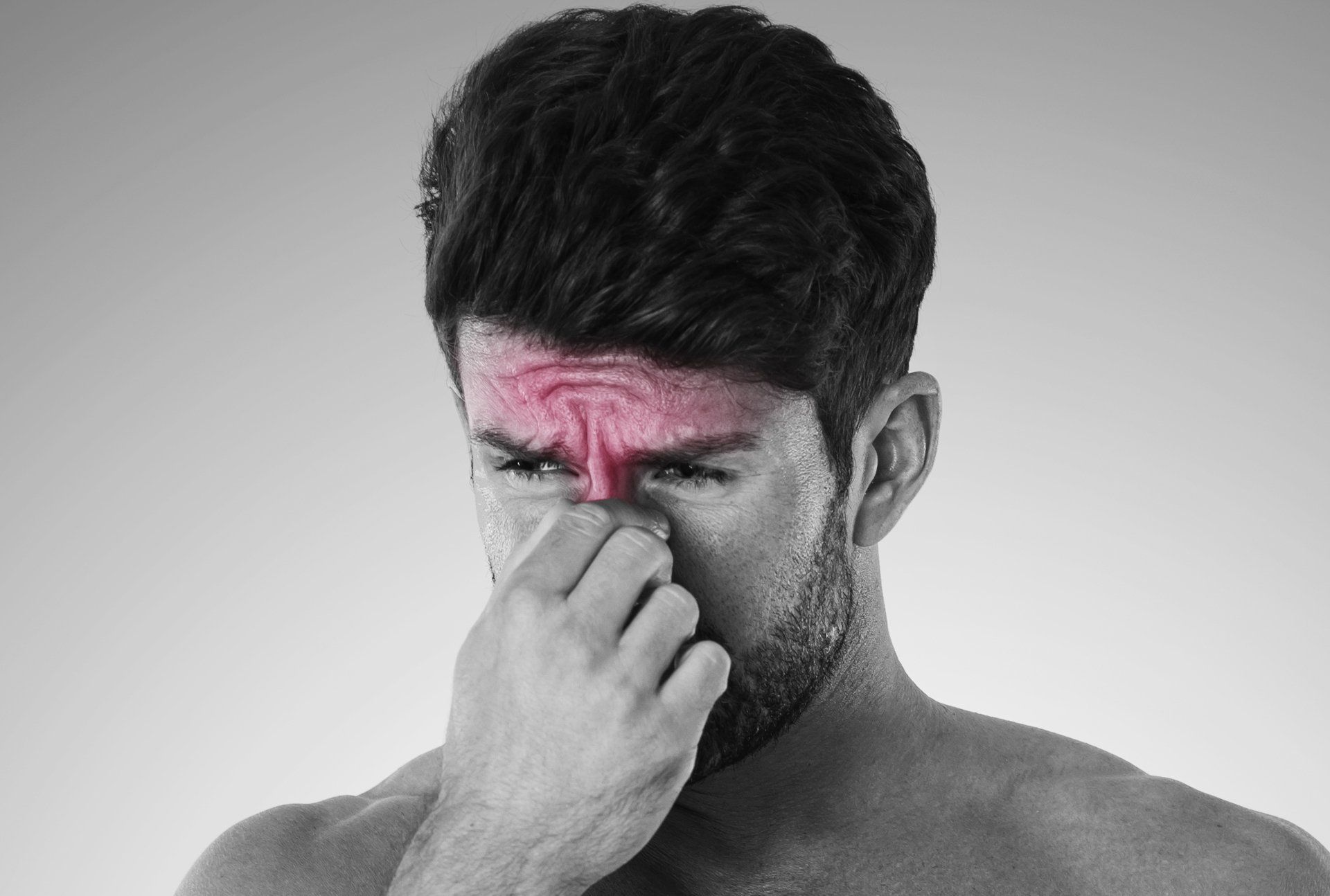 Man with red-highlighted brow and nose, holding his nose, possibly experiencing sinus pain or discomfort.