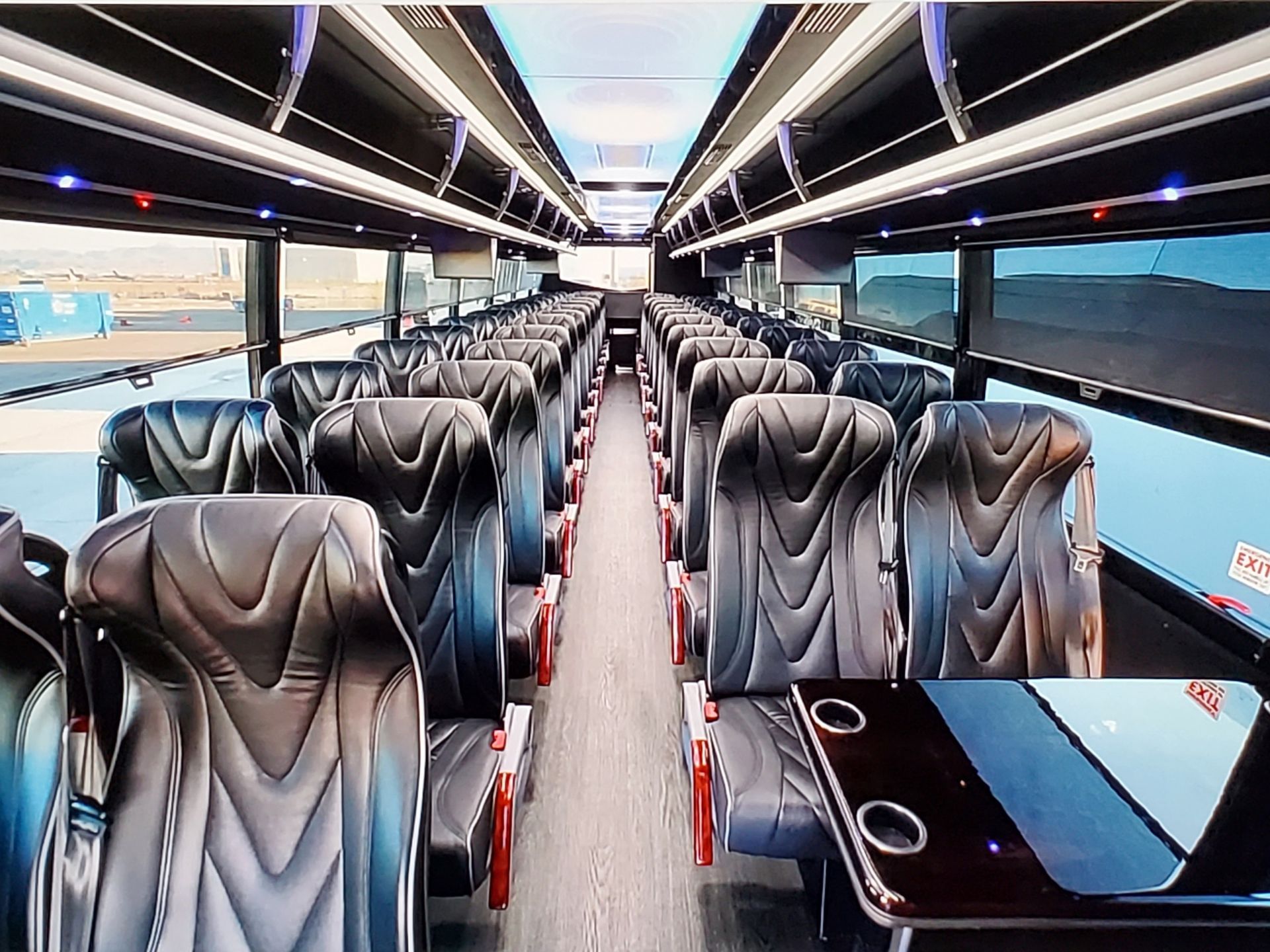 The inside of a bus with lots of seats and tables.