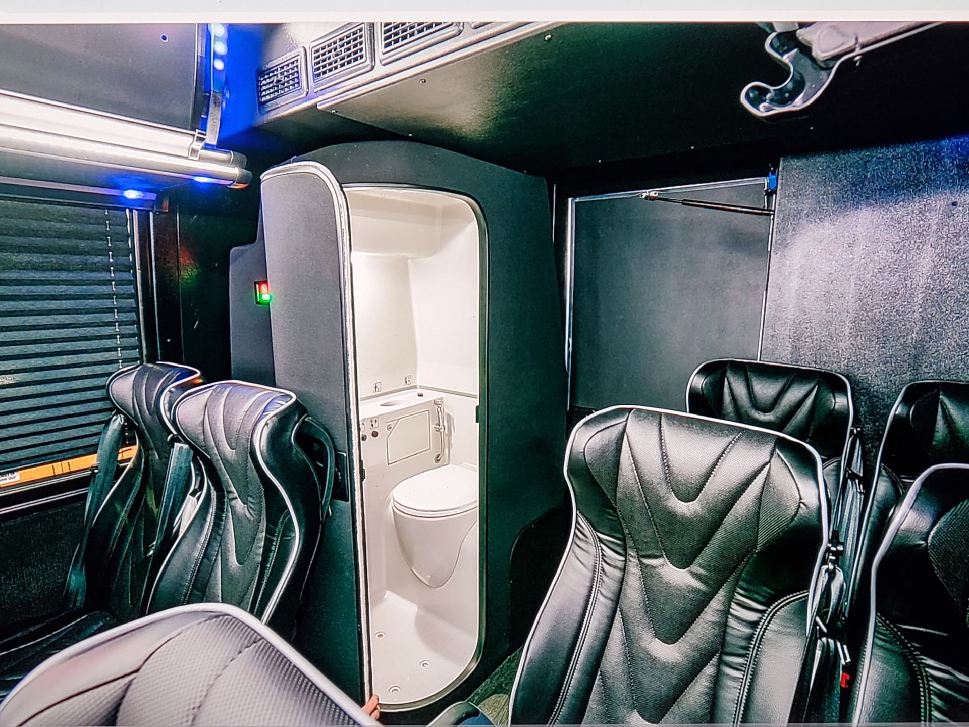 The inside of a bus with a toilet between the seats.