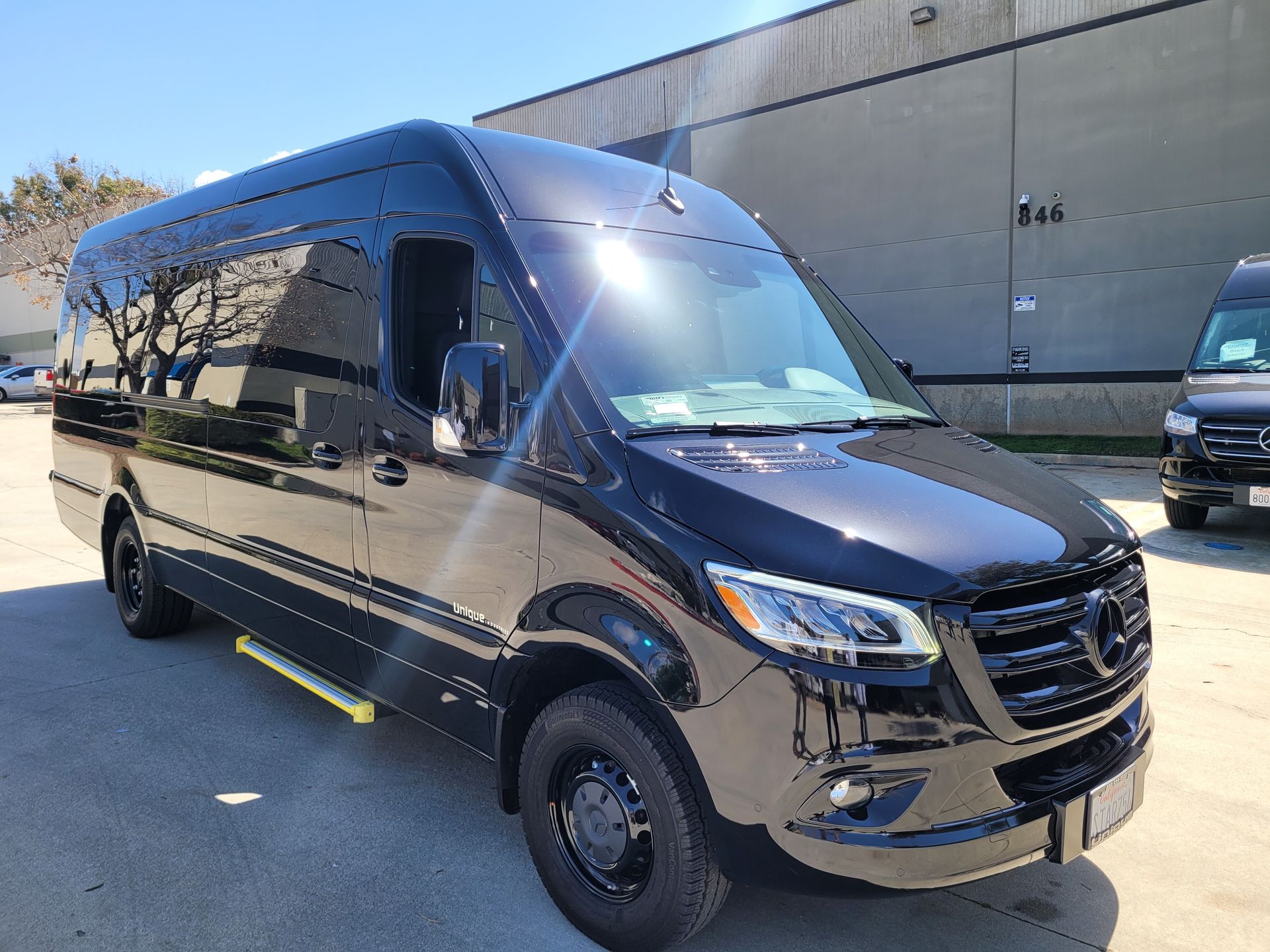 A black van is parked in front of a building.