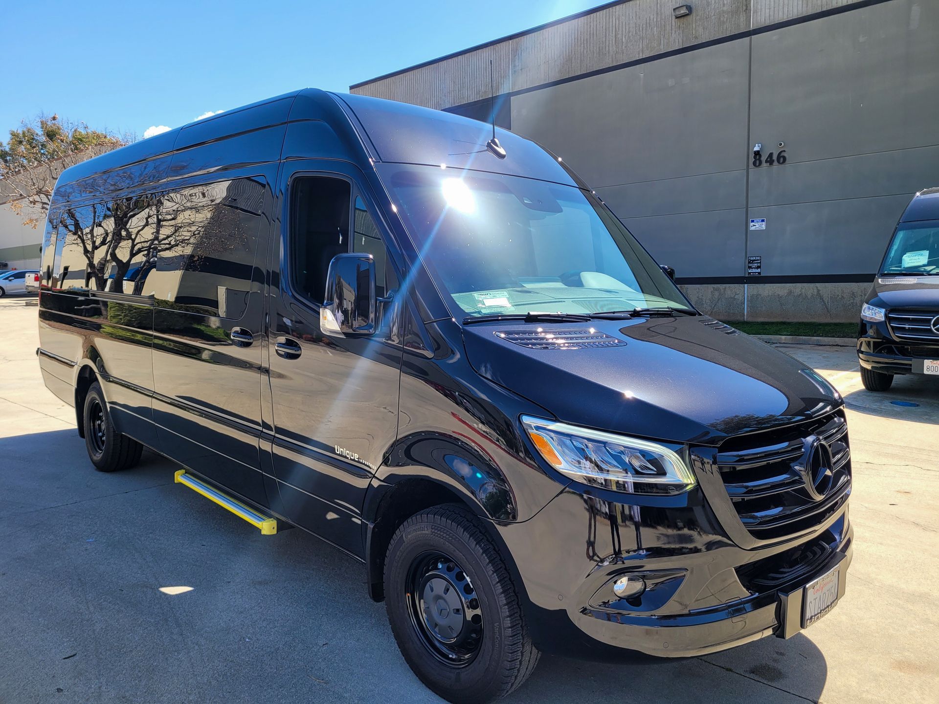 A black van is parked in front of a building.