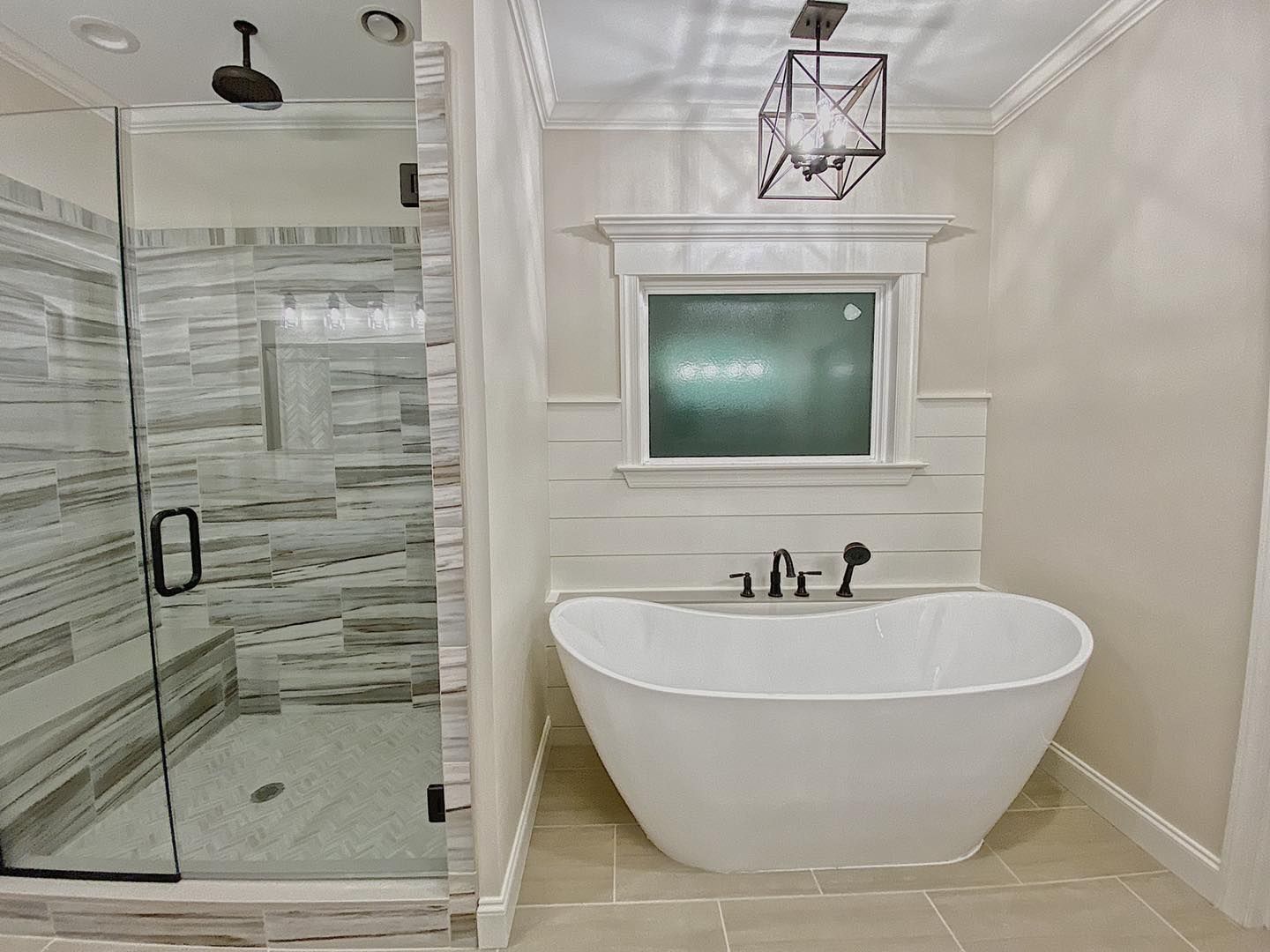 Bathroom with a glass-enclosed shower on the left and a freestanding bathtub on the right. Beige and white tones.