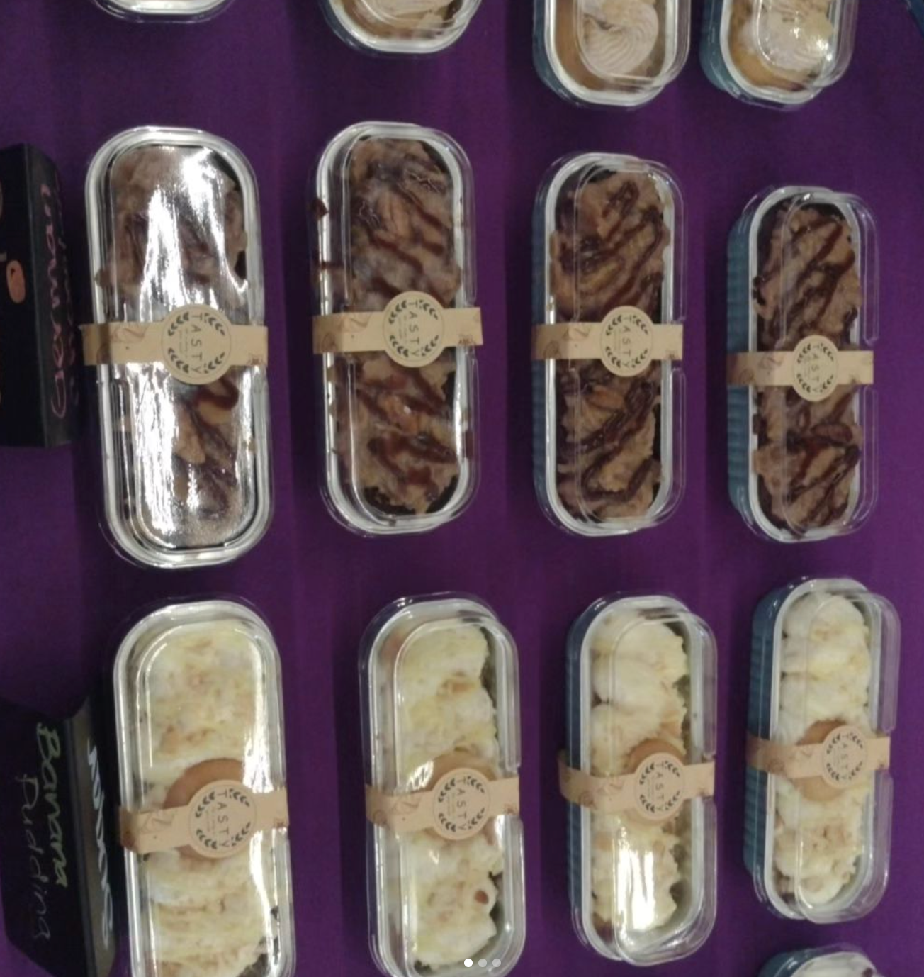 A variety of desserts are lined up on a purple surface
