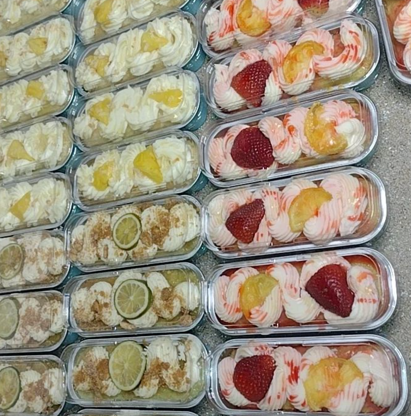 A variety of desserts are lined up on a table.