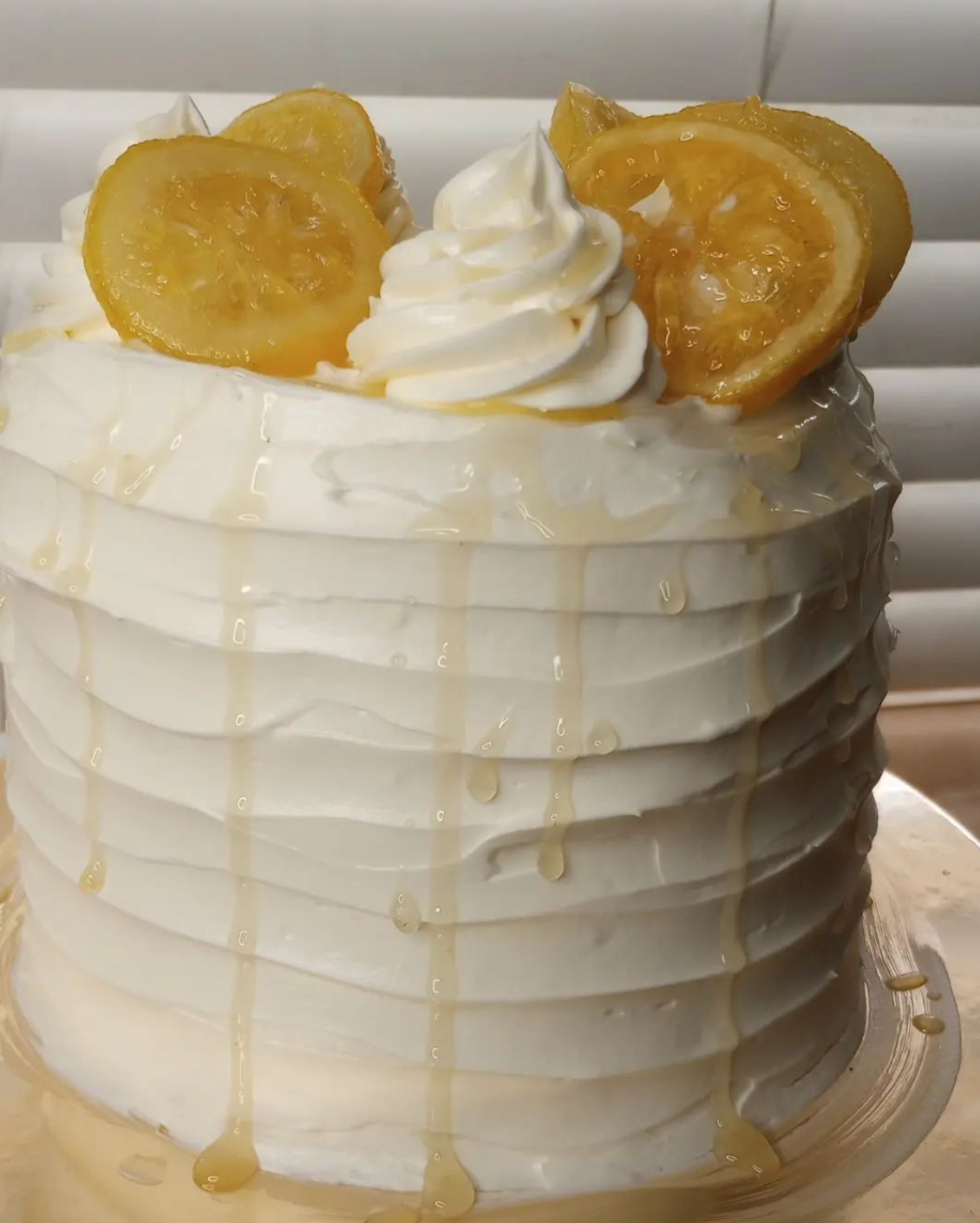 A cake with whipped cream and lemon slices on top