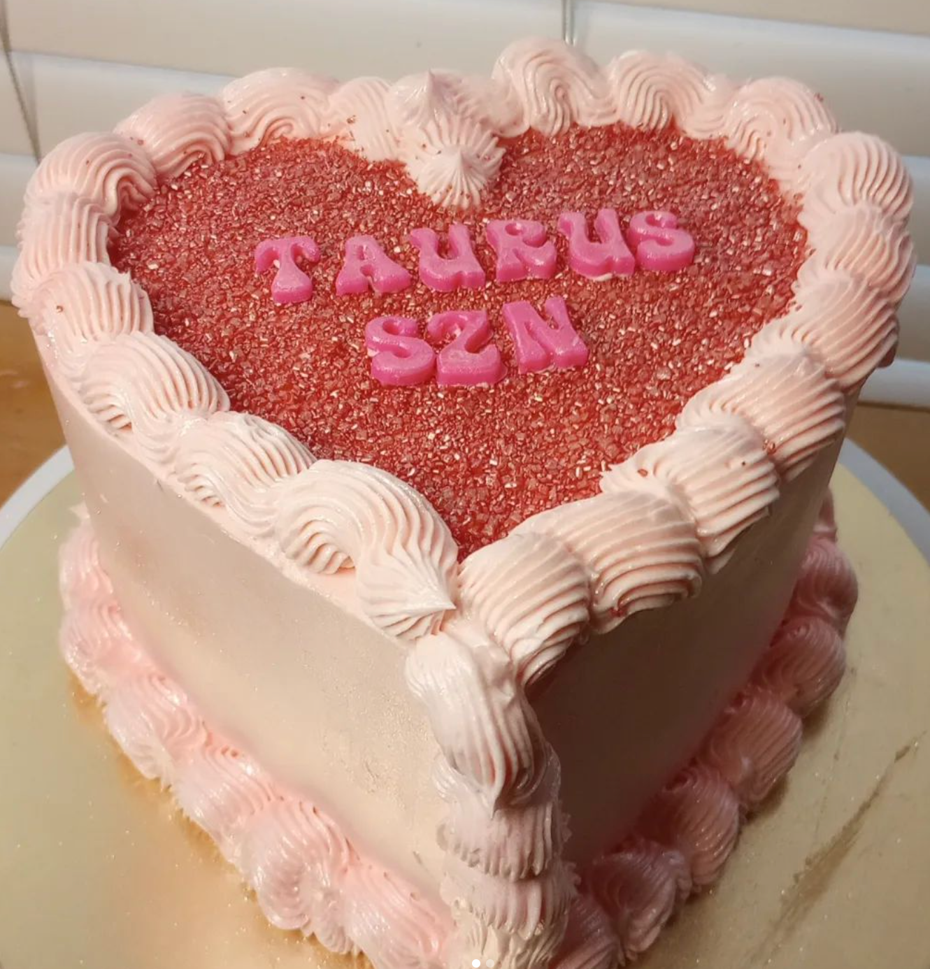A heart shaped cake with taurus written on it