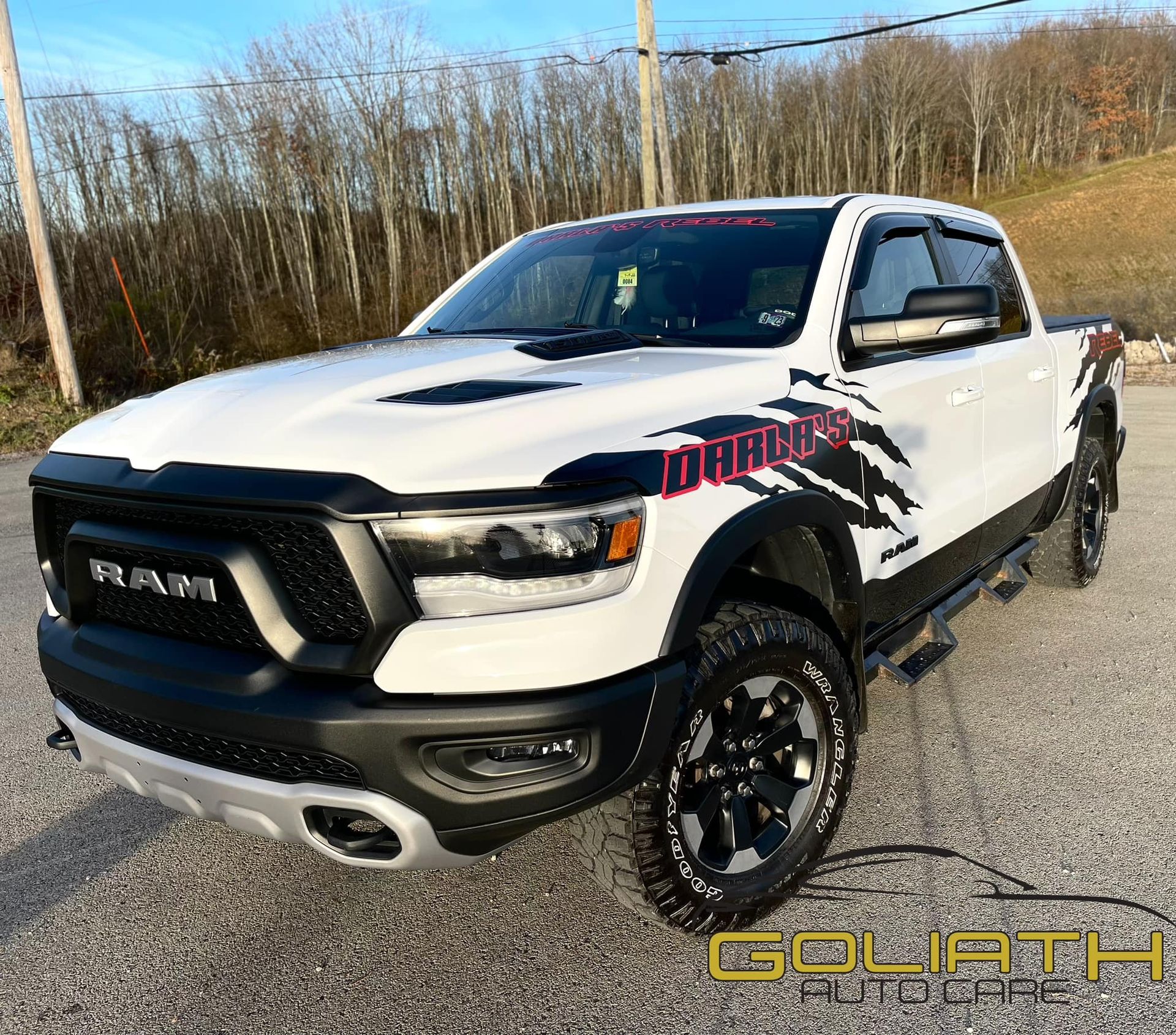 a white ram truck is parked on the side of the road .