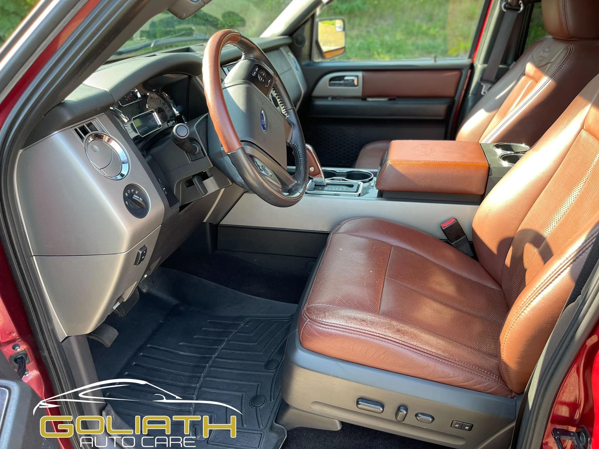 the interior of a red ford expedition with brown leather seats