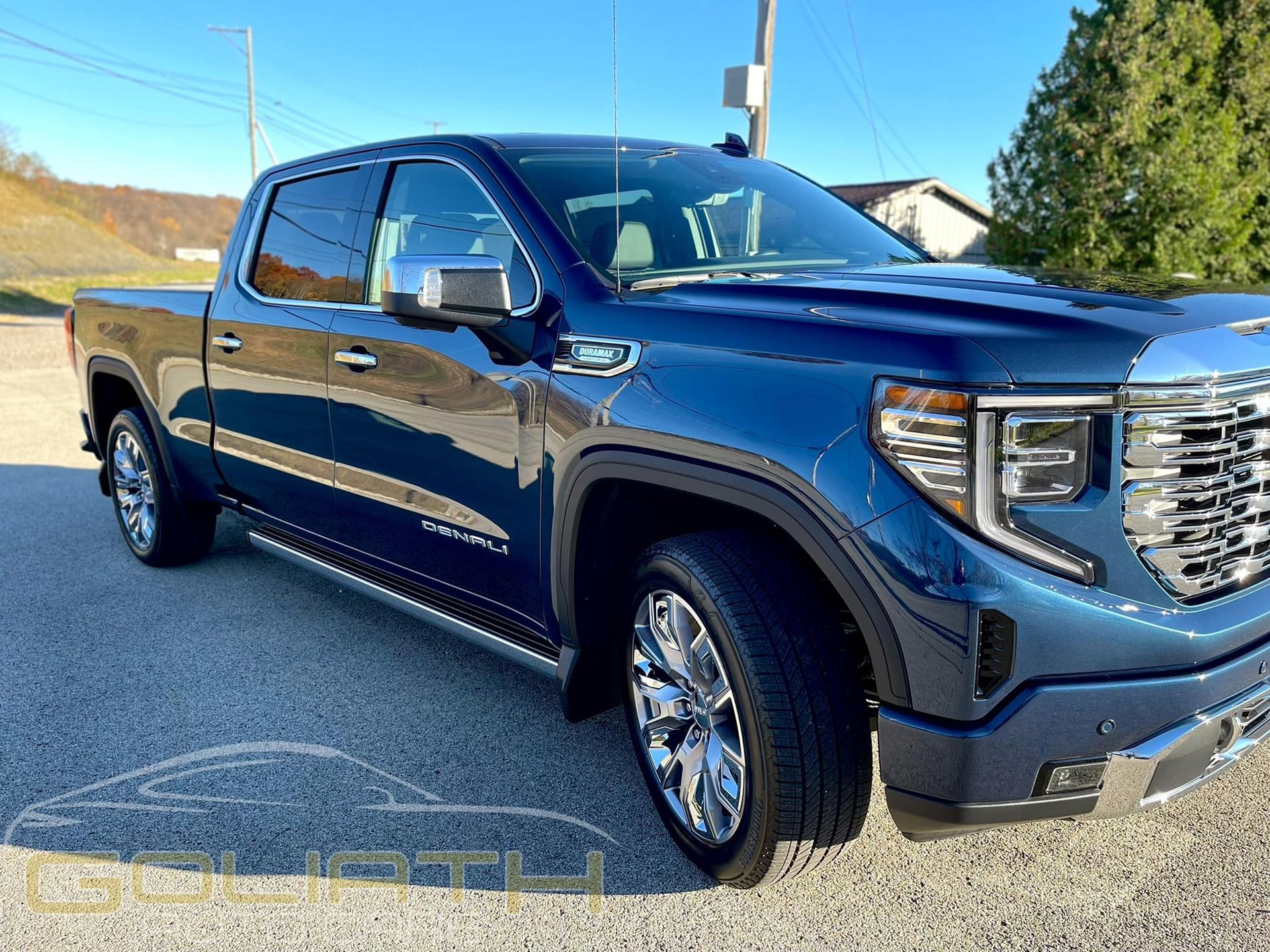 a blue pickup truck is parked on the side of the road .